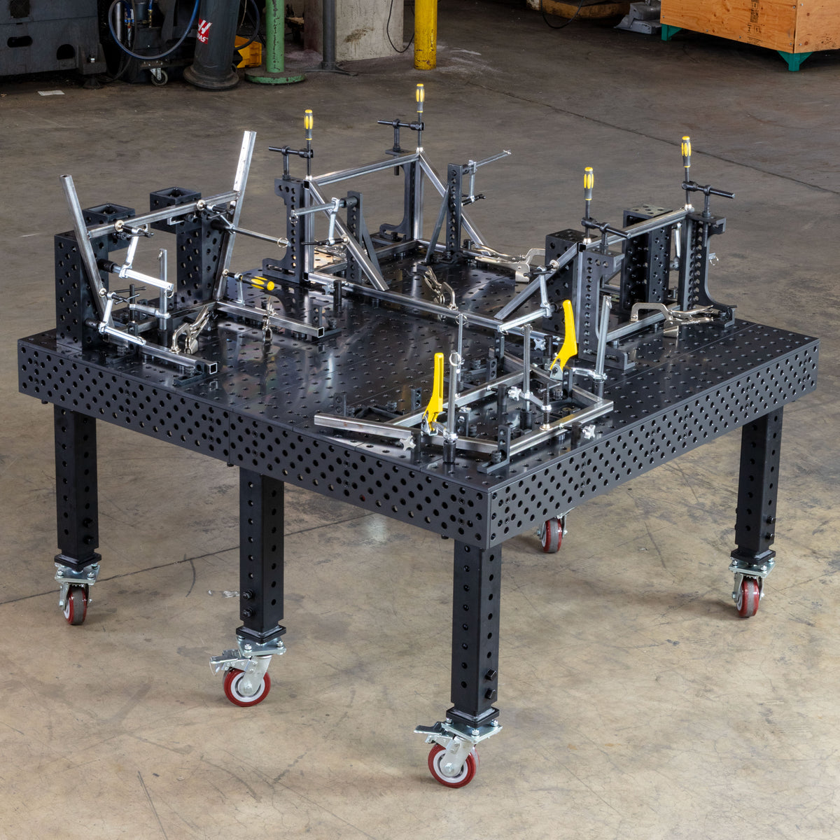 Alpha 5/8 4 ft by 4 ft table on caster legs with a tube frame fixtured on the top and side plates using 5/8 inch clamps, squares and stops